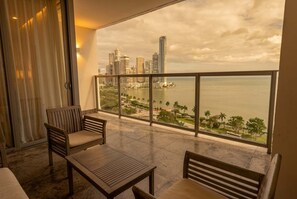 A balcony with a cityscape view, a table, and two chairs. - Apartamento 14J en YOO, Vista al mar con 2 recámaras (Panamá)