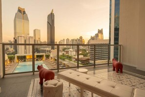 A rooftop terrace with a pool, seating area, and a view of the city skyline. - Apartamento 14J en YOO, Vista al mar con 2 recámaras (Panamá)