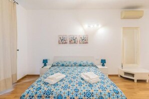 A bedroom with a bed, bedside tables, a mirror, and wall art. - AP4 - Apartment in the heart of Milan (Milano)