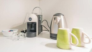 A kitchenette with a coffee maker, a kettle, and two mugs on a white countertop. - AP4 - Apartment in the heart of Milan (Milano)