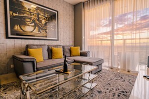 A modern living room with a sofa, glass coffee table, and a large window with curtains. - 20B Apartamento de 1 recamara, con vista al mar (Panamá)