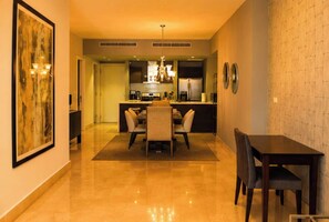 A modern kitchen with a dining area, a chandelier, and a large painting on the wall. - 20B Apartamento de 1 recamara, con vista al mar (Panamá)