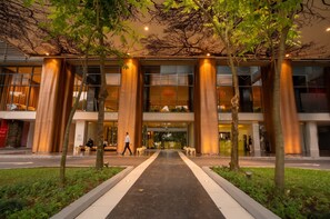 A modern building with large glass windows, a central entrance, and a pathway leading to the entrance. - 20B Apartamento de 1 recamara, con vista al mar (Panamá)