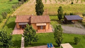 Une maison avec une piscine, un patio doté de chaises longues et un panneau solaire.
