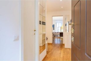 A hallway with a wooden floor, white walls, and a door on the right. - AP6 Apartment in the Cathedral area (Milano)