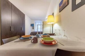 A dining area with a table set for two, a lamp, and a view of the room. - AP6 Apartment in the Cathedral area (Milano)