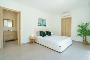 Ein Schlafzimmer mit Bett, Nachttisch, Spiegel, Wandairconditioner und einer Topfpflanze.