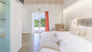 Een hotelkamer met een bed, een stoel, een bureau, een televisie en een schuifdeur naar buiten.