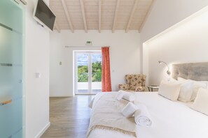 A hotel room with a bed, a chair, a desk, a TV, and a sliding glass door to the outside. - Room 'Monte Do Sol 1' with Mountain View, Wi-Fi and Air Conditioning (S. Luís)