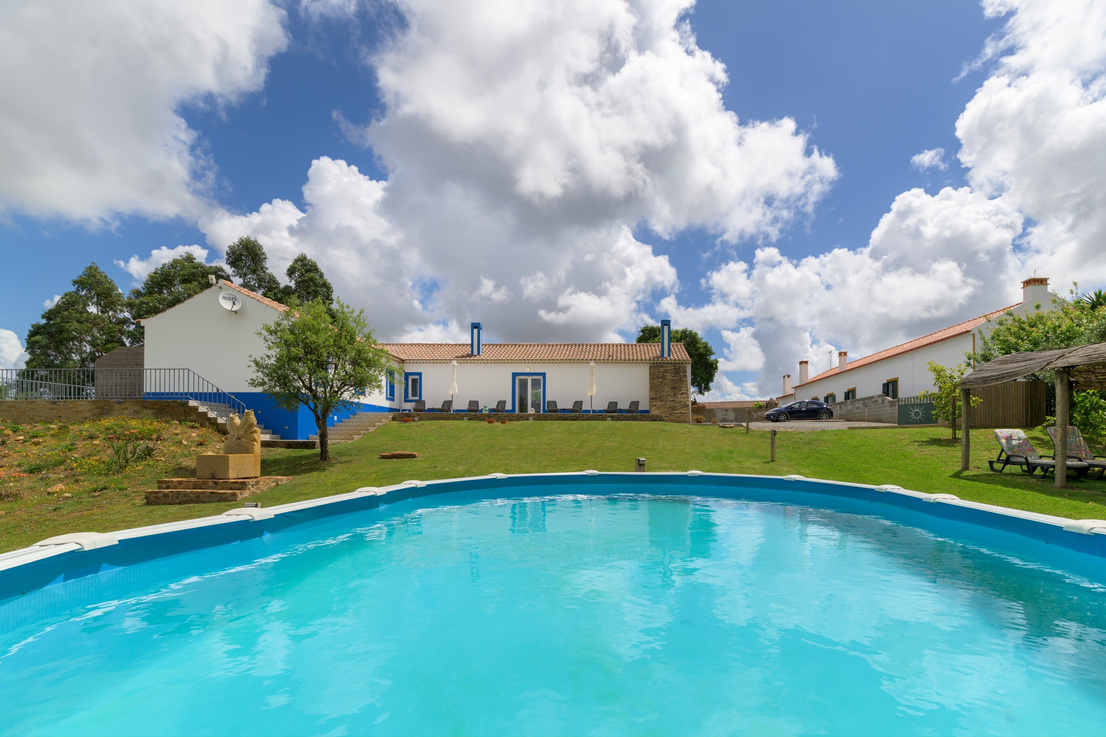 Piscina com céu azul e nuvens ao fundo.