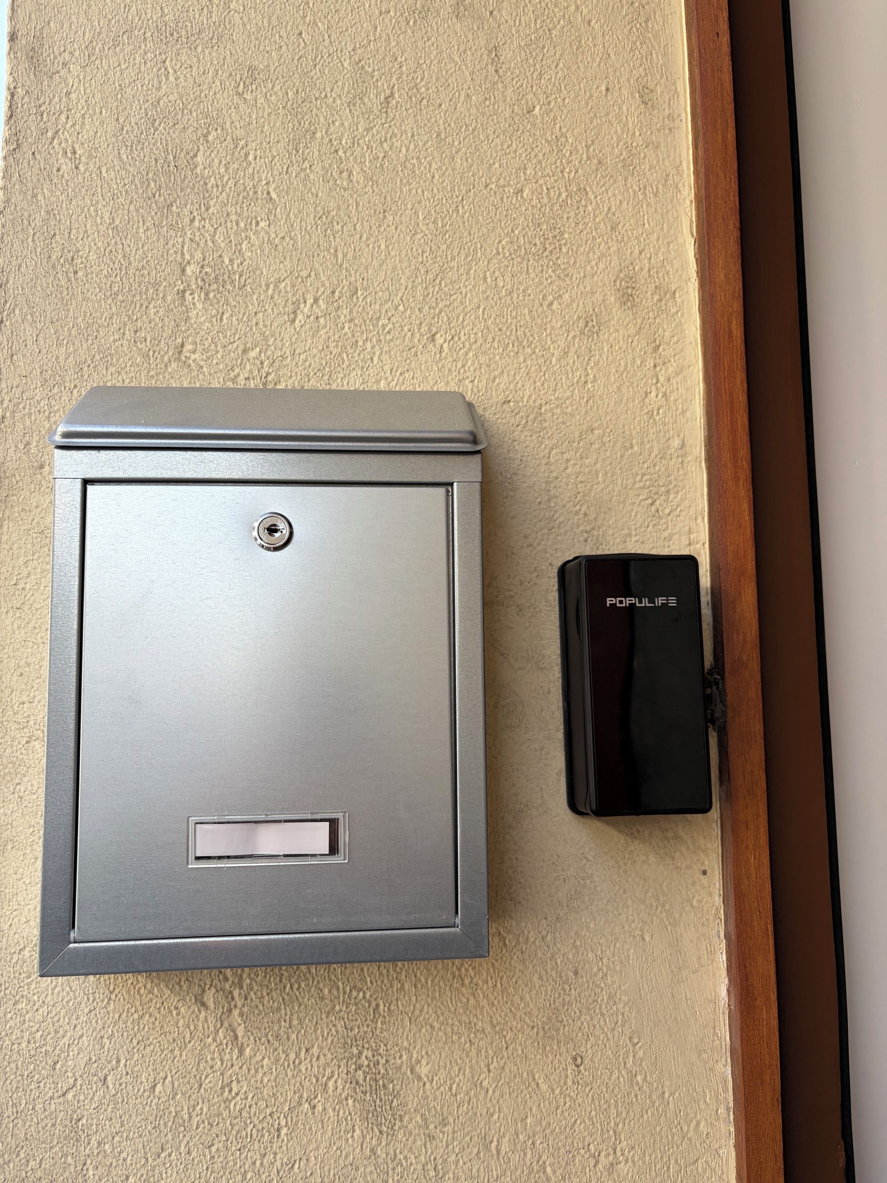 A metallic utility box with a lock and a black device labeled 'POPULIFE' beside it.