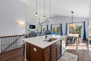 A spacious kitchen with a central island, wooden cabinets, and pendant lighting. - Starlight Cove𓇼Spacious+Stunning | 0.6mi to Beach (Oak Island)