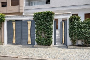 A modern house with a tiled entrance, a staircase, and a balcony.