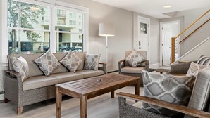 A living room with a sofa, armchairs, a coffee table, and a lamp. - Drift Cottage Steps to Beach (Old Orchard Beach)