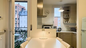 Eine moderne Küche mit Essbereich und Blick auf den Balkon, inklusive Mikrowelle.