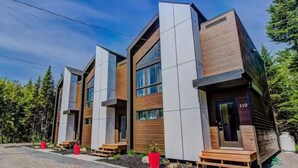 Un edificio moderno a più piani con ampie finestre e un rivestimento che combina legno e cemento.