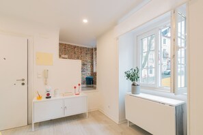 A room with a white radiator, a window with a view, a white cabinet, and a door. - Apartment for rent at Rua de Santo Estevão 25, Santa Maria Maior, Lisbon. (Lisboa)