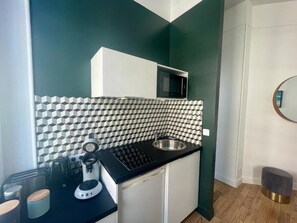 Une cuisine compacte équipée d’un four à micro-ondes, d’un grille-pain et d’un évier.