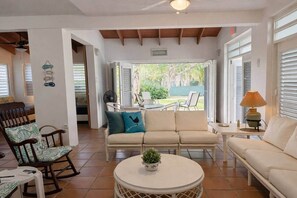 A living room with a sofa, chairs, a round table, and a lamp. - Lovely Beach Villa in Vega Alta Puerto Rico near to Dorado (Sabana, Vega Alta, Puerto Rico)