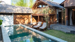 A pool with lounge chairs, a wooden deck, and a thatched-roof structure. - Mizu Homes (Lembongan Island)