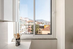 Eine Küche mit Fensterblick auf eine Stadtlandschaft.