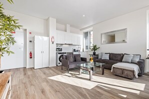 Eine moderne Wohnung mit Wohnbereich, Küche und Essbereich.