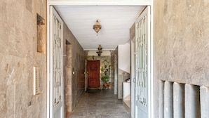 A hallway with a wooden door at the end, a light fixture above, and a radiator on the right. - Majorelle Luxury Retreat Fully Equiped (Marrakech)
