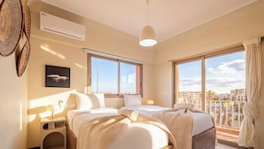 A hotel room with two beds, a large window, and a view of the city. - Majorelle Luxury Retreat Fully Equiped (Marrakech)