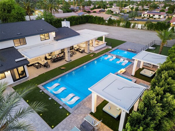 A residential property with a large swimming pool, a covered patio, and a well-maintained lawn. - True Country/1 Acre/65ft Pool (Bermuda Dunes)
