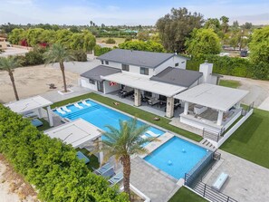 A large house with a swimming pool, outdoor seating, and a covered patio. - True Country/1 Acre/65ft Pool (Bermuda Dunes)