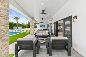 An outdoor patio with a pool, seating area, and a view of the backyard. - True Country/1 Acre/65ft Pool (Bermuda Dunes)