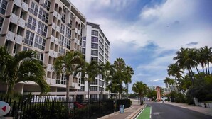 A multi-story hotel with balconies, palm trees, and a clear sky. - Prime Location in Condado Puerto Rico (San Juan)
