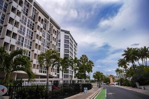 A multi-story hotel with balconies, palm trees, and a clear sky. - Prime Location in Condado Puerto Rico (San Juan)