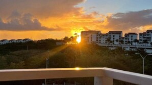 Tramonto su zona residenziale con edifici e vegetazione.