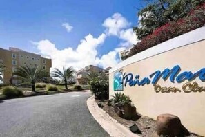 A hotel entrance with a sign reading 'Pina Moreno Beach Club' and a road leading to the building. - P1508-Comfortable apartment in Fajardo (Fajardo)