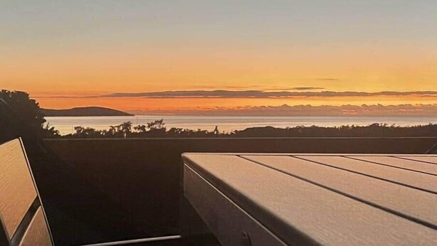Un banco de madera con vistas a un atardecer.