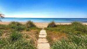 Ein Weg, der zu einem Strand mit blauem Himmel führt.