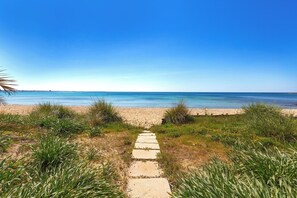 A pathway leading to a beach with clear skies. - Nella Suites - Bilo PT (Porto Cesareo)