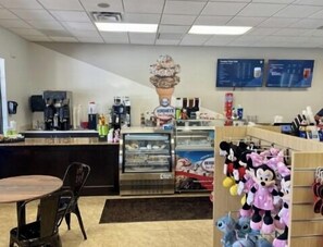 A small cafe with a counter, chairs, a display case, and plush toys on shelves. - Spacious 6BR Family Villa, 13 miles to Disney, Private Pool, Resort Waterpark (Kissimmee)