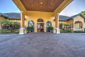A building with a covered entrance, columns, and potted plants. - Spacious 6BR Family Villa, 13 miles to Disney, Private Pool, Resort Waterpark (Kissimmee)