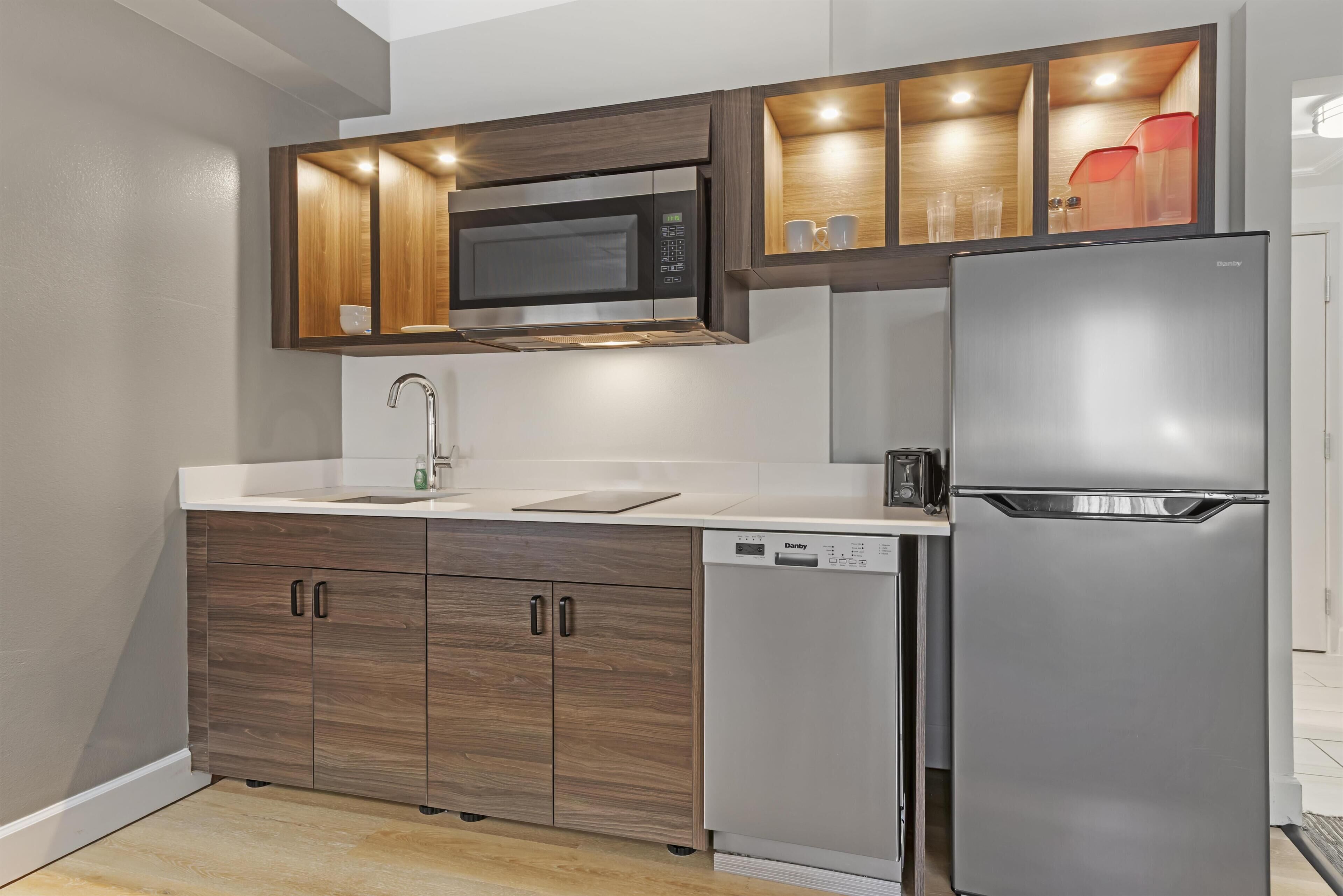 A modern kitchen with a built-in microwave, refrigerator, and dishwasher.