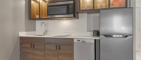 A modern kitchen with a built-in microwave, refrigerator, and dishwasher.