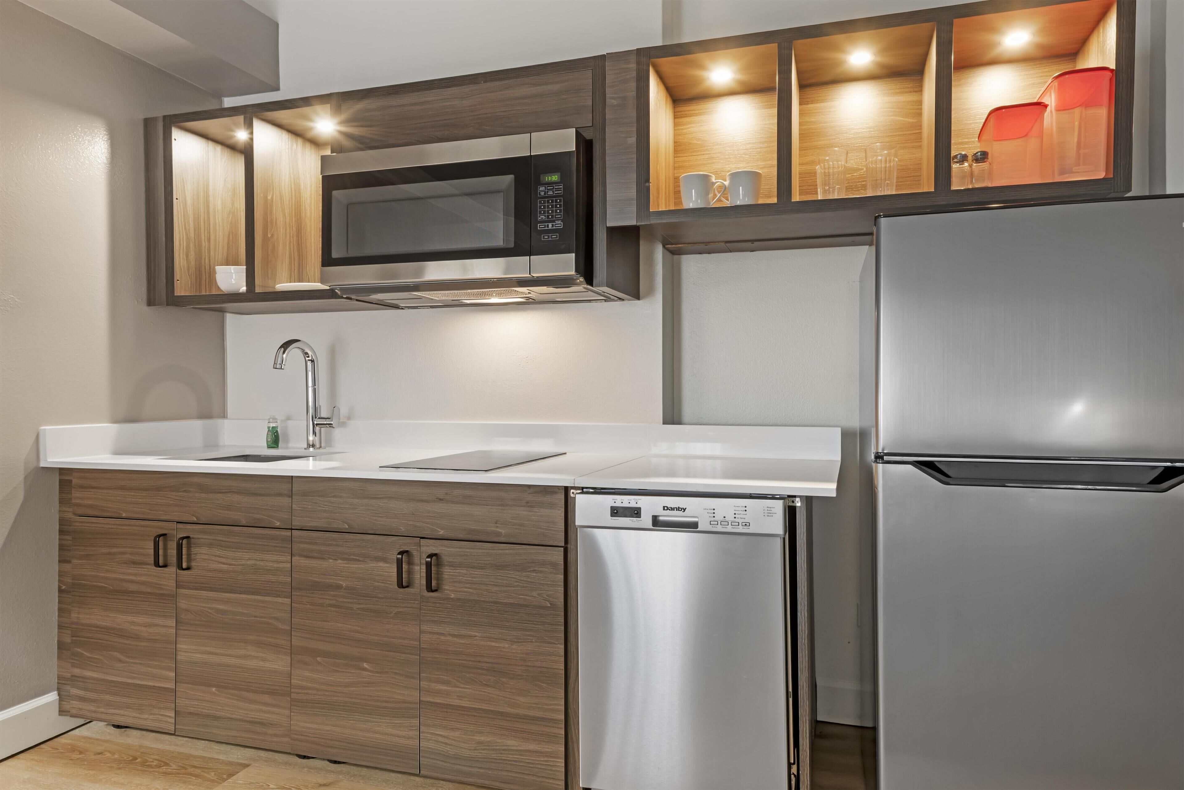 A modern kitchen with a built-in microwave, dishwasher, and refrigerator.