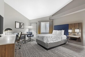 A hotel room with a bed, desk, chair, and two bedside tables with lamps. - Executive Residency By Best Western Denver East (Denver)