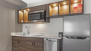Una cocina moderna con microondas, lavavajillas y refrigerador integrados.