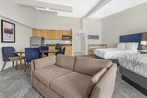 A hotel room with a sofa, a bed, a desk with a chair, a microwave, and a refrigerator. - Executive Residency By Best Western Denver East (Denver)