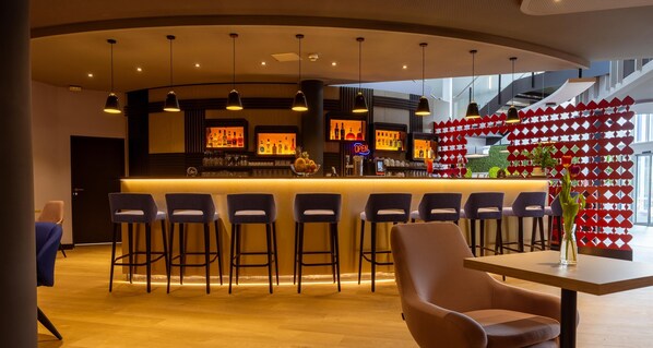 A bar area with a curved counter, multiple bar stools, and a seating area with a table and chairs. - Best Western Hotel Altenburger Land (Altenburg)
