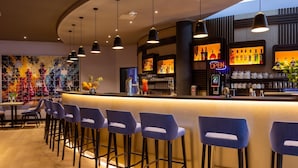 A bar area with a counter, stools, and a neon sign. - Best Western Hotel Altenburger Land (Altenburg)