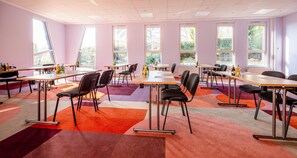 A conference room with multiple tables and chairs, large windows, and a colorful carpet. - Best Western Hotel Altenburger Land (Altenburg)