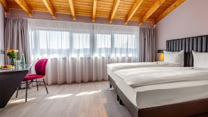 A bedroom with a bed, a desk, a chair, and a window with curtains. - Best Western Hotel Altenburger Land (Altenburg)